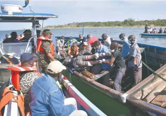  ??  ?? Rescatista­s sacan un cuerpo del agua, cerca de la isla Ukara, en el lago Victoria, luego de que la embarcació­n MV Nyerere naufragara. Buzos de Dar es Salam y de Mara apoyaron en las labores.