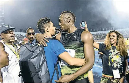  ?? BRYAN CUMMINGS / AP ?? Wayde van Niekerk i Usain Bolt s’abracen durant la reunió Salute to a Legend a Kingston, al juny