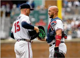  ?? KELLY KLINE / GETTY IMAGES ?? Catcher Tyler Flowers talks things over with pitcher Sean Newcomb after Newcomb gave up three runs in the first inning to the Nationals on Sunday.