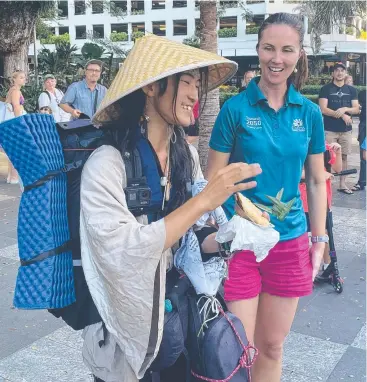  ?? ?? Councillor Amy Eden hands Uni a meat pie at the end of his 3000km journey.