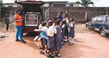  ?? AFP ?? Funmi Illori (left), who launched the mobile library project, talks to the children from Bethel Nursery and Primary school in Lagos about the importance of reading.