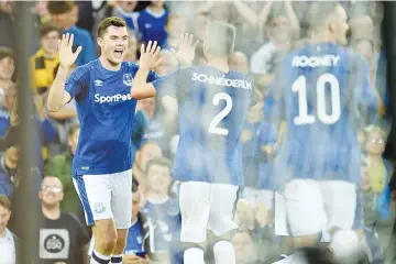  ?? — AFP photo ?? Everton's English defender Michael Keane (L) celebrates with teammates after scoring the opening goal during the UEFA Europa League playoff round, first leg football match between Everton and Hajduk Split at Goodison Park in Liverpool, north west...
