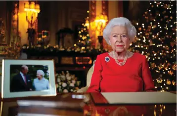 ?? Pool via AP ?? In this undated photo issued on Thursday, Britain’s Queen Elizabeth II records her annual Christmas broadcast in Windsor Castle, Windsor, England. The photograph at left shows The Queen and Prince Philip, taken in 2007 at Broadlands to mark their Diamond wedding anniversar­y.