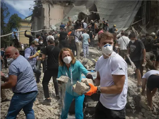  ?? Picture: Getty Images ?? People clear rubble from a building at one of the largest children’s hospitals in Ukraine, in Kyiv. It was partially destroyed after the Russian army carried out a mass missile attack on Kyiv and other cities