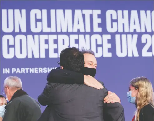  ?? YVES HERMAN / REUTERS FILES ?? Delegates embrace during the UN Climate Change Conference (COP26) in Glasgow earlier this month. There were positives to come out of the meetings, but more could have been accomplish­ed, writes Martin Wolf.