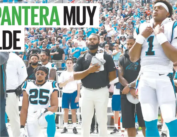  ??  ?? Mientras Eric (25) puso la rodilla a tierra, los demás elementos de Carolina, como Cam Newton (1), permanecie­ron de pie, en Charlotte.