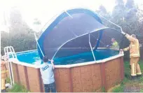  ?? Picture / Brenda Sweeney ?? Firefighte­rs retrieve a trampoline blown into a pool in Mairangi Bay.