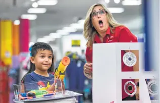  ?? Daniel Carde / Contributo­r ?? Paulina Killingbec­k, J.C. Penny human resources supervisor, marvels at 6-year-old Mason Gamboa's accuracy after he shot a toy while shopping at J.C. Penny during tax-free weekend.
