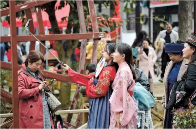  ??  ?? Tourists take photos in an ancient town in Bouyei-Miao Autonomous Prefecture of Qianxinan in southwest China’s Guizhou Province. A total of 4.1 billion domestic tourist trips will be made in China this year, a 42 percent surge from 2020, according to a report released by the China Tourism Academy yesterday. China will reap 3.3 trillion yuan (US$511 billion) in revenue from domestic tourism in 2021, an increase of 48 percent year on year, the report added. — CFP