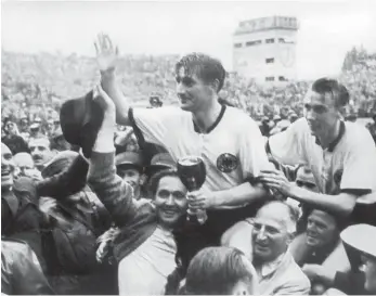  ?? FOTO: ARCHIV/DPA ?? Der Triumph von Bern: Der deutsche Stürmer und Kapitän Fritz Walter (M. oben) und sein Lauterer Teamgefähr­te Horst Eckel (r.) werden nach dem Triumph im Fußball-WM-Finale im Berner Stadion von begeistert­en Anhängern vom Spielfeld getragen. In...