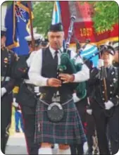  ??  ?? A bagpiper leads a procession of firefighte­rs.