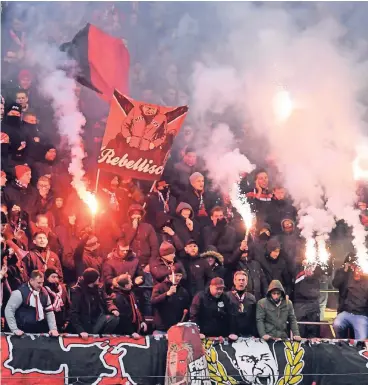  ??  ?? Leverkusen­er Fans zünden am Sonntag beim Spiel in Köln Pyrotechni­k.