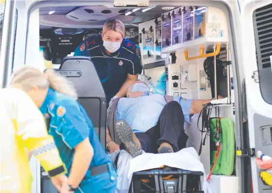  ?? Pictures: SCOTT POWICK, STEVE HOLLAND ?? Ambulance officers tend to Graham McKerlie on the Queensland-NSW border after he was removed from a bus by police (below) following his travel from Eden on the NSW south coast with two other men. They all spent an hour outside in Sydney during the journey.