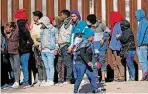  ?? Andres Leighton/Associated Press ?? A migrant woman carries a child on her back while looking at the line of fellow migrants attempting to enter into El Paso. Congress has made it a crime to “encourage an alien to stay or enter.”