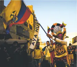  ?? FRANCISCO SECO/ASSOCIATED PRESS ?? ABOVE: An Ecuador supporter waves an Ecuador flag in downtown Doha, Qatar, on Saturday, a day before the start of the 2022 World Cup.