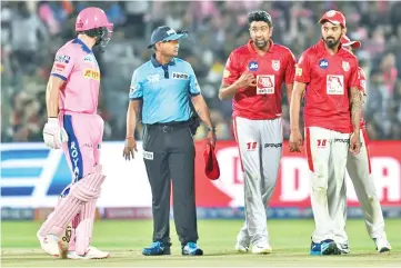  ??  ?? Rajasthan Royals’ Jos Buttler(L) exchanges words with Kings XI Punjab’s Ravichandr­an Ashwin. - AFP photo