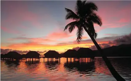  ?? Michelle Newman / For the Express-News ?? The sunset comes to your doorstep when your room for the evening is in an overwater bungalow.