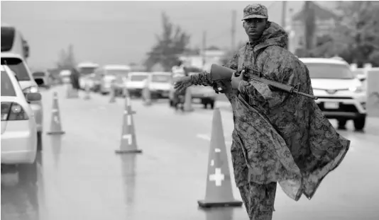  ?? FILE ?? A Jamaica Defence Force soldier directing traffic in Greenwood, the border of Trelawny and St James, during the state of emergency that was declared in St James in 2018. After being discontinu­ed on January 31, 2019, a new iteration of the security clampdown has been triggered in St James, Hanover, and Westmorela­nd.