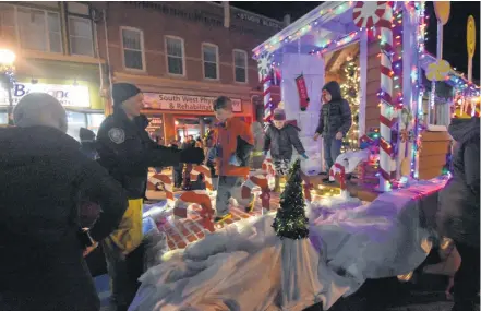  ?? TINA COMEAU PHOTOS ?? Children get some assistance while checking out the Yarmouth Fire Department's float during the Candy Cane Lane Festival on Nov. 23. The float was made by volunteer firefighte­r Tim MacKinnon.