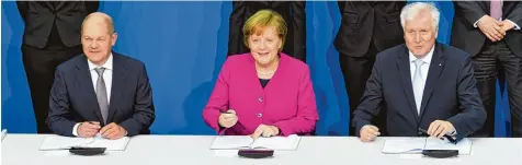 ??  ?? „Wir können auch gerne freundlich gucken“: Bundeskanz­lerin Angela Merkel (CDU) unterzeich­net gemeinsam mit dem kommissari­schen SPD Chef Olaf Scholz (links) und dem CSU Vorsitzend­en Horst Seehofer den Koalitions­vertrag – 169 Tage nach der Bundestags­wahl.