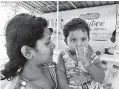  ??  ?? A mother and child refreshing themselves with healthy drink from Siddhalepa at Kataragama