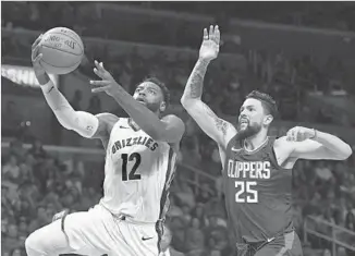  ?? Michael Owen Baker Associated Press ?? TYREKE EVANS of the Memphis Grizzlies drives to the basket ahead of Austin Rivers of the Clippers in the second half. Evans gave the Clippers fits, scoring 20 points in Memphis’ 113-104 victory.