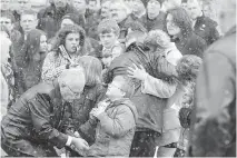  ??  ?? Grieving parents Teenah Snowden (in pink coat) and Eric Courtney (to her left, holding baby William) are comforted by friends and family.