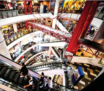  ?? — AFP photo ?? People take escalators and walk inside Terminal 21 shopping mall in Bangkok.