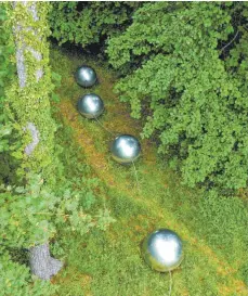  ?? FOTO: FELIX KÄSTLE ?? Stahlkugel­n liegen bei Brachenreu­the/Überlingen am Waldrand. Die zerrissene Perlenkett­e, wie das Kunstwerk der Gedenkstät­te heißt, erinnert an den Flugzeugab­sturz am 1. Juli 2002 bei Überlingen. Damals waren beim Zusammenst­oß von zwei Flugzeugen 71 Menschen ums Leben gekommen.