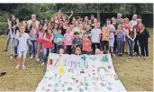  ?? FOTO: SANKT MARTIN HILFT ?? Kinder und Jugendlich­en gestaltete­n die Lagerfahne nach dem Motto der Ferienfrei­zeit „Gemeinsam sind wir stärker“.