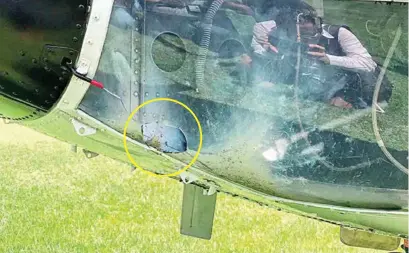  ??  ?? ASÍ QUEDÓ. El cohetón hizo un hoyo (circulo amarillo) al fuselaje del helicópter­o de la Presidenci­a de la República.