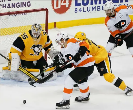  ?? Peter Diana/Post-Gazette photos ?? Philadelph­ia’s Nicolas Aube-Kubel sets up Claude Giroux, top right, for the winning goal with less than three minutes remaining Thursday night at PPG Paints Arema.The goal completed a Flyers rally from a 3-0 first-period deficit.