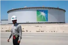  ?? — Reuters ?? An Aramco employee walks near an oil tank at Saudi Aramco’s Ras Tanura oil refinery and oil terminal in Saudi Arabia.