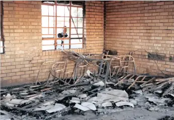  ?? PICTURE: CHESTER MAKANA ?? A child peers into what remains of a classroom at the Mugoidwa Secondary School in Vuwani which was attacked by arsonists on Tuesday night.