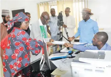  ?? From left: APC Kogi-West senatorial aspirants, Chief (Mrs) Doyin Ibikunle Eshanumi and Dr. Williams Toyin Akanle submit a petition calling for the cancellati­on of the Kogi-West senatorial primary to APC National Chairman’s Confidenti­al Secretary, Barriste ??