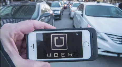  ?? CP FILE PHOTO ?? The Uber logo is seen in front of protesting taxi drivers at the courthouse in Montreal on Feb. 2, 2016. Ridesharin­g Now for BC says the ride-hailing model proposed in B.C. legislatio­n tabled this week is more of an expanded taxi industry, rather than true ride sharing.