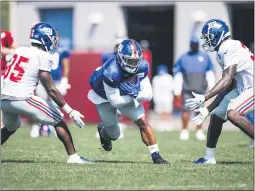  ?? COURTESY OF GIANTS.COM ?? Giants running back Saquon Barkley, middle, runs between two defenders during training camp Monday in East Rutherford.