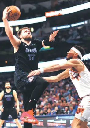 ?? — AFP photo ?? Doncic (le ) of the Dallas Mavericks drives inside for a shot against Devin Booker of the Phoenix Suns in the second half at American Airlines Centre in Dallas, Texas.
