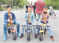  ??  ?? ‘Under 14’ champ Awang (centre) with second-placed Darly Aluinson Patrick (left) and third-placed Mohammad Hazriq Aiman Raduan display their trophies for the last Mini Pocketbike Club Race held at State Stadium carpark here.