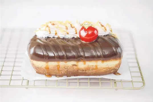  ?? THE GLASS KNIFE ?? The Banana Split Donut from the Glass Knife, is a cream-filled banana diplomat topped with a dark chocolate ganache glaze and finished with strawberry whipped cream.