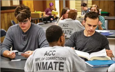  ?? PHIL SKINNER / FOR THE AJC ?? College students Ben Price (left) and Zachary Reynolds help a prisoner in a GED class at Athens-Clarke County Correction­al Institutio­n in Athens. Prisoners have been getting their GEDs thanks to the help of two recent UGA honor students.