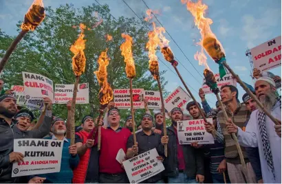  ?? AP ?? Kashmiri activists hold torches and march in a protest against the rape and murder of an 8-year-old girl in Srinagar on Saturday. —