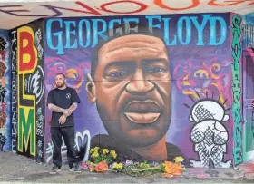  ?? SENTINEL ZHIHAN HUANG / MILWAUKEE JOURNAL ?? Artist Chris Burke stands in front of a new mural in memory of George Floyd at the corner of North Avenue and Holton Street.