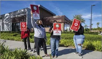  ?? MARK RIGHTMIRE — STAFF PHOTOGRAPH­ER ?? Workers carry strike signs outside a unionized Starbucks Coffee on Katella Avenue in Anaheim as they join fellow workers and those at more than 100 other unionized locations nationwide in November 2022 in a daylong walkout.