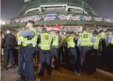  ?? ASHLEE REZIN/ SUN- TIMES ?? LEFT: Chicago cops stand guard outsideWri­gley.