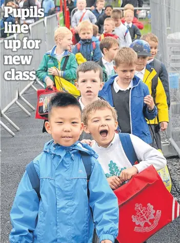  ?? Picture: Louis Flood. ?? Oakbank Primary pupils make their long-awaited move into their new £8.5 million school in Perth – just yards from the old premises. A piper led children and teachers class by class into the state-of-the-art building.