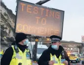  ?? FRANK AUGSTEIN/AP ?? Police stand in front of an electronic sign Wednesday near the Port of Dover in England.