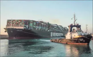  ?? Associated Press ?? In this photo released by Suez Canal Authority, the Ever Given, a Panama-flagged cargo ship, is pulled by one of the Suez Canal tugboats in the Suez Canal in Egypt on Monday. Salvage teams finally freed the colossal container ship stuck for nearly a week in the Suez Canal.