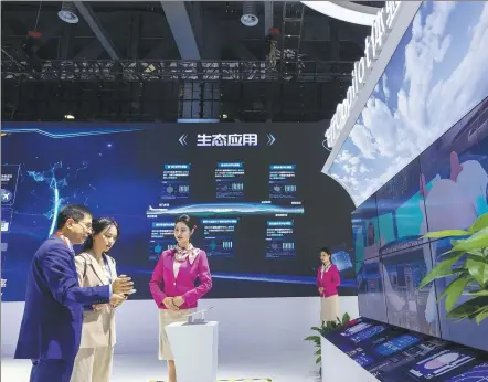  ?? ZHU HAIWEI / FOR CHINA DAILY ?? An employee introduces an AI large model to a visitor (middle) during the 2nd Global Digital Trade Expo in Hangzhou, Zhejiang province.