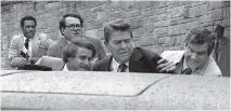  ?? R O N E D MO N D S / T H E A S S O C I AT E D P R E S S F I L E S ?? U. S. president Ronald Reagan is guarded after being shot in 1981. Secret Service agent Jerry Parr, to the right of Reagan, was credited with saving his life.